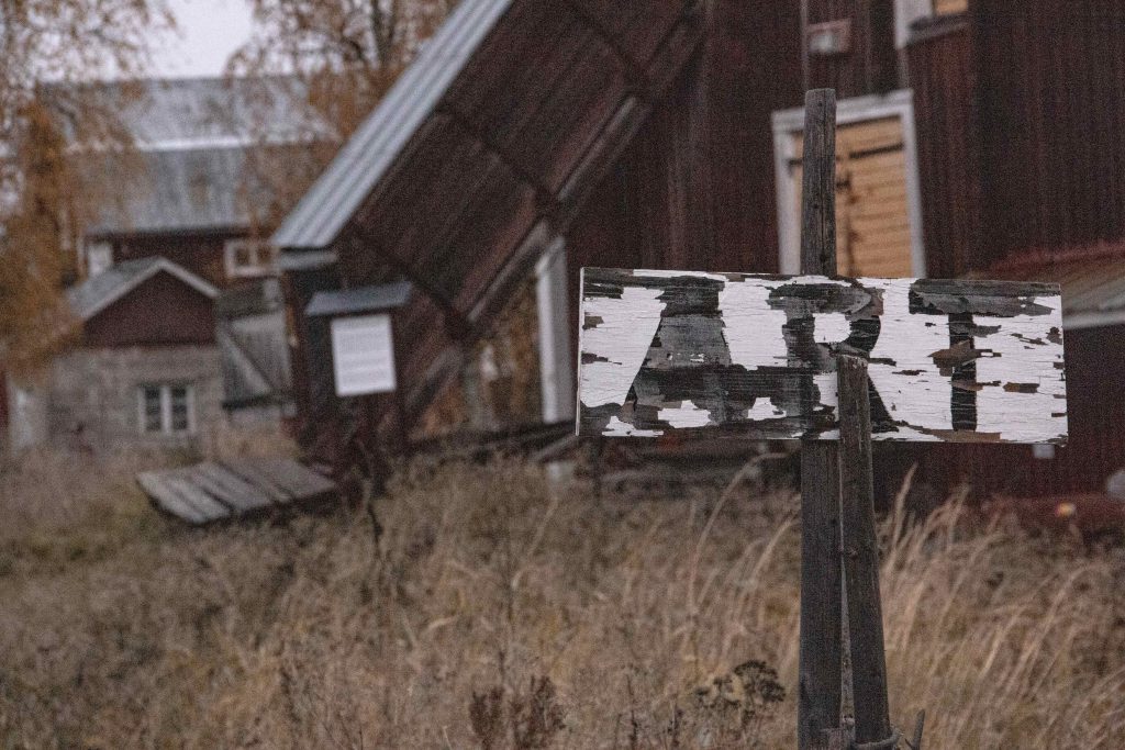 A sign pointing towards an old art museum in an old town in Lapland